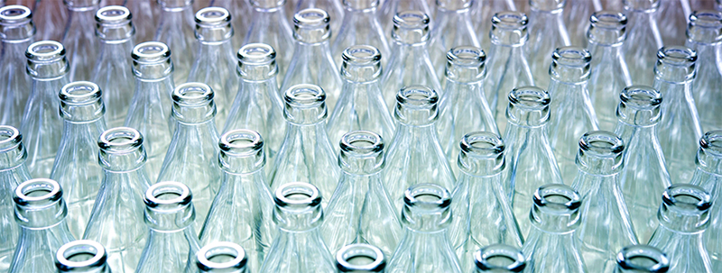 a group of empty glasses in front of a water bottle