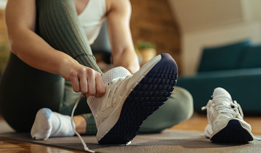 woman lacing sneaker