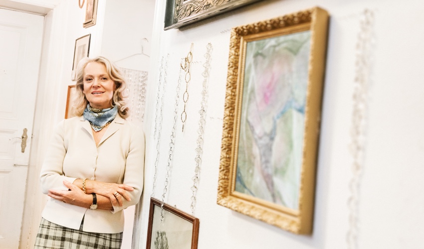 Woman standing in a hallway with hanging art