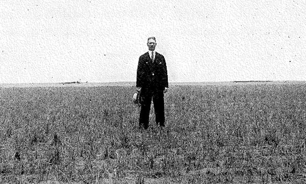 a man standing on top of a grass covered field