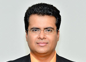 a man wearing a suit and tie smiling and looking at the camera