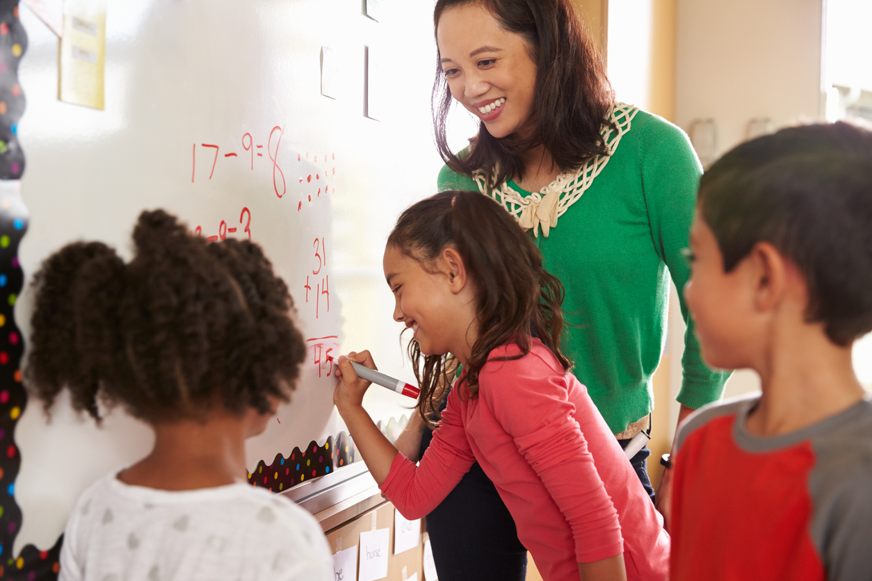 children in front of white board