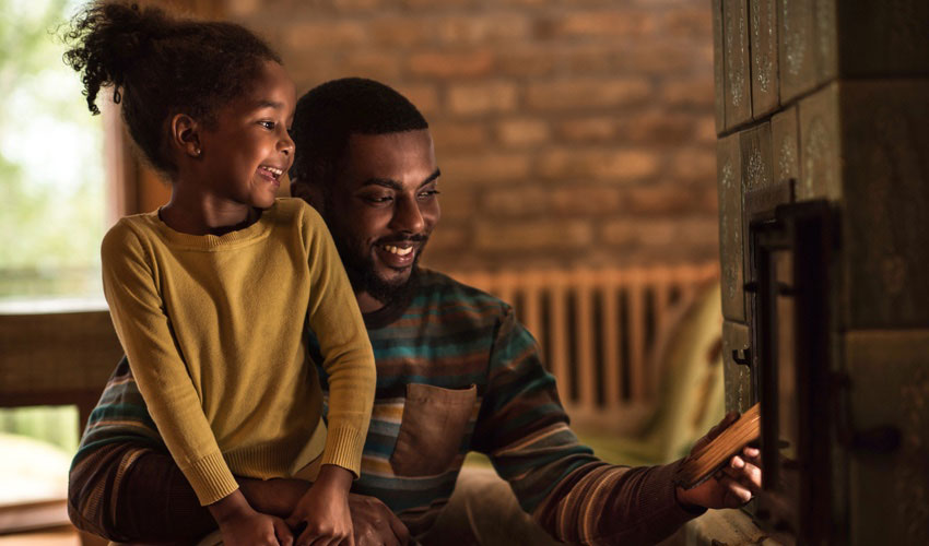 Father and daughter near fireplace