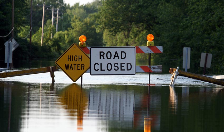 flooded street with road closed barrier